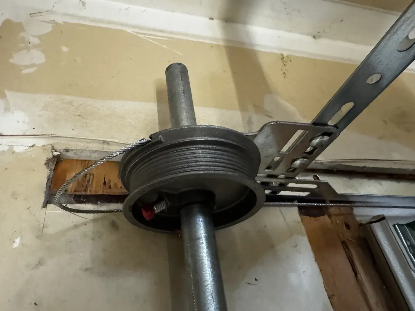 A lift cable seated and wound onto the cable drum at the end of the torsion shaft.