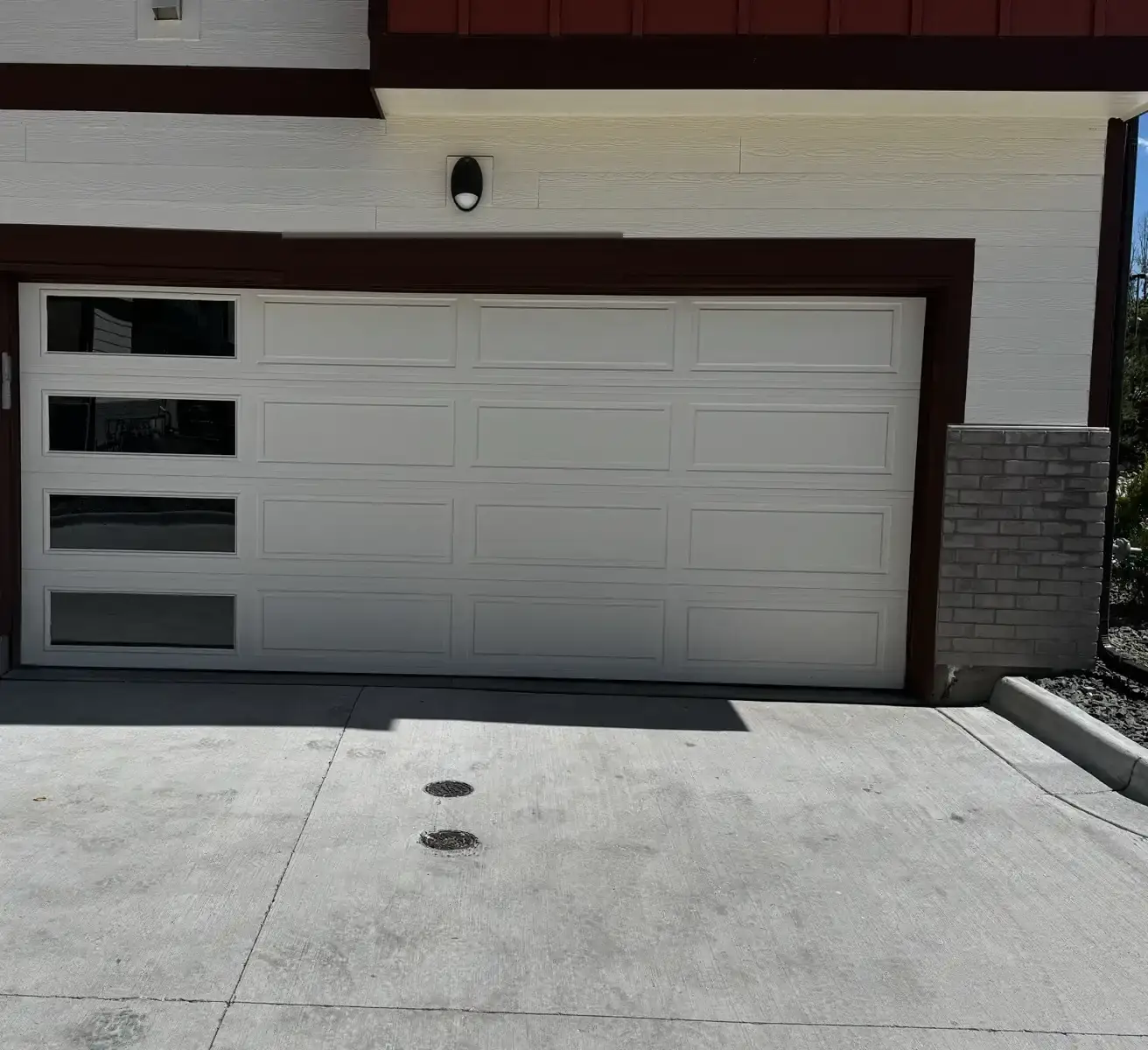 A white short-panel garage door with four stacked windows in the left-hand column.