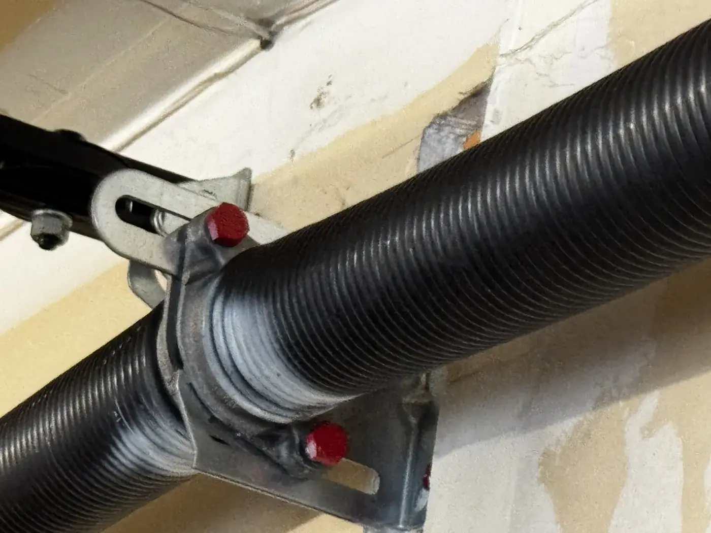 The centre bearing plate between two torsion springs, set screws marked in red.