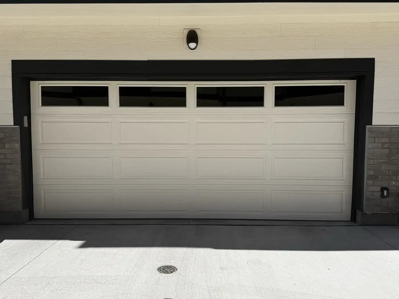 A white short-panel garage door with a full-width row of small windows across the top section.